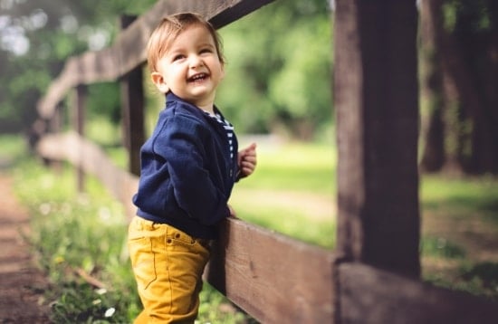 petite-fille-contre-une-barriere-bois